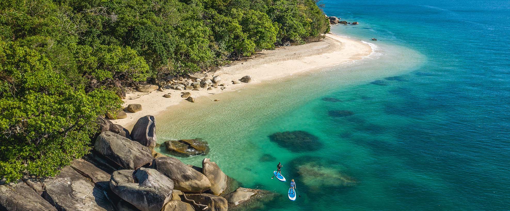 Two paddleboarders near beautiful beach on turqouise water