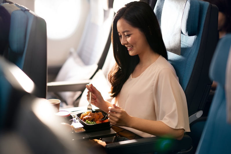 Passenger Enjoying Her Meal In Singapore Airlines Economy Class